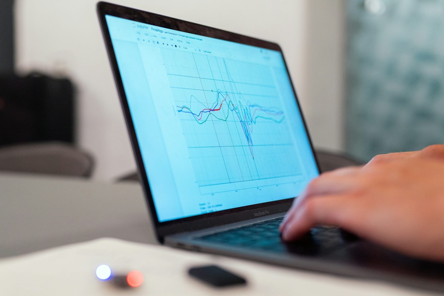 Ein Mann arbeitet an einem Laptop, zeigt Grafiken und Datenanalysen.